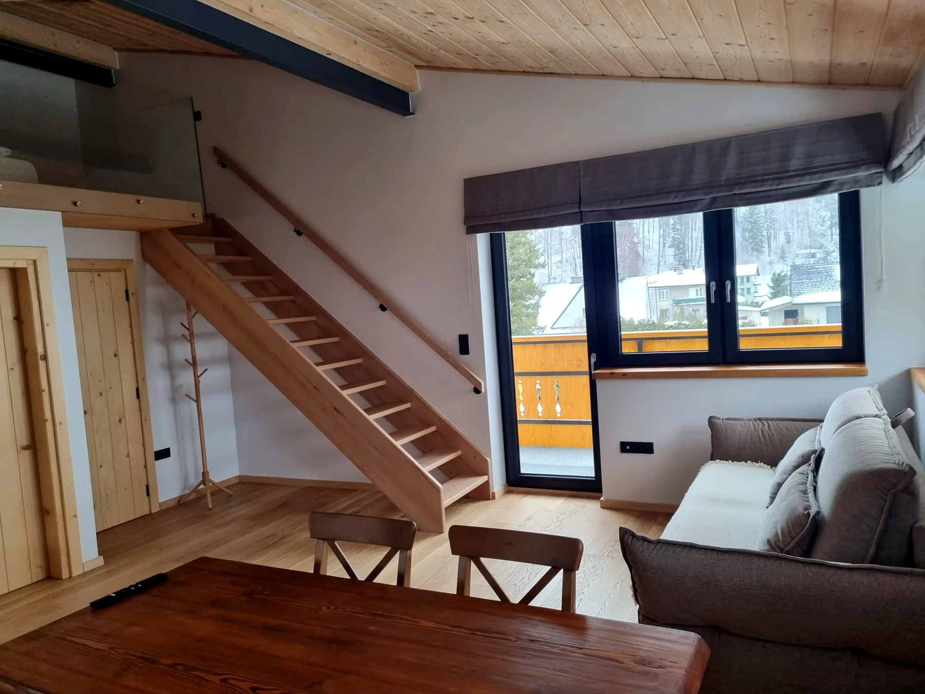 Salon Apartamentu 4 z sofą, schodami na antresolę i dużym oknem